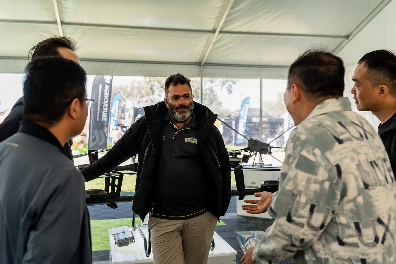 A tech talking through an Agras with visitors at a field day